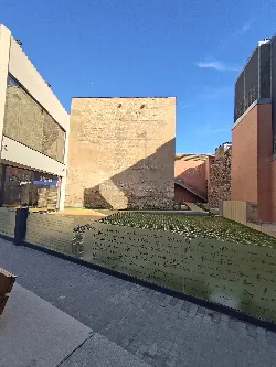 Torre musulmana en Silla con edificios modernos y cielo azul.