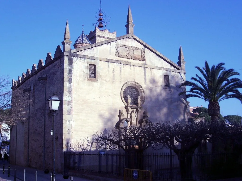 Iglesia de Sant Feliu en Alella, con fachada de piedra y detalles góticos.