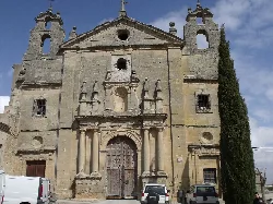 Fachada de una iglesia antigua con columnas y campanarios en Huete.