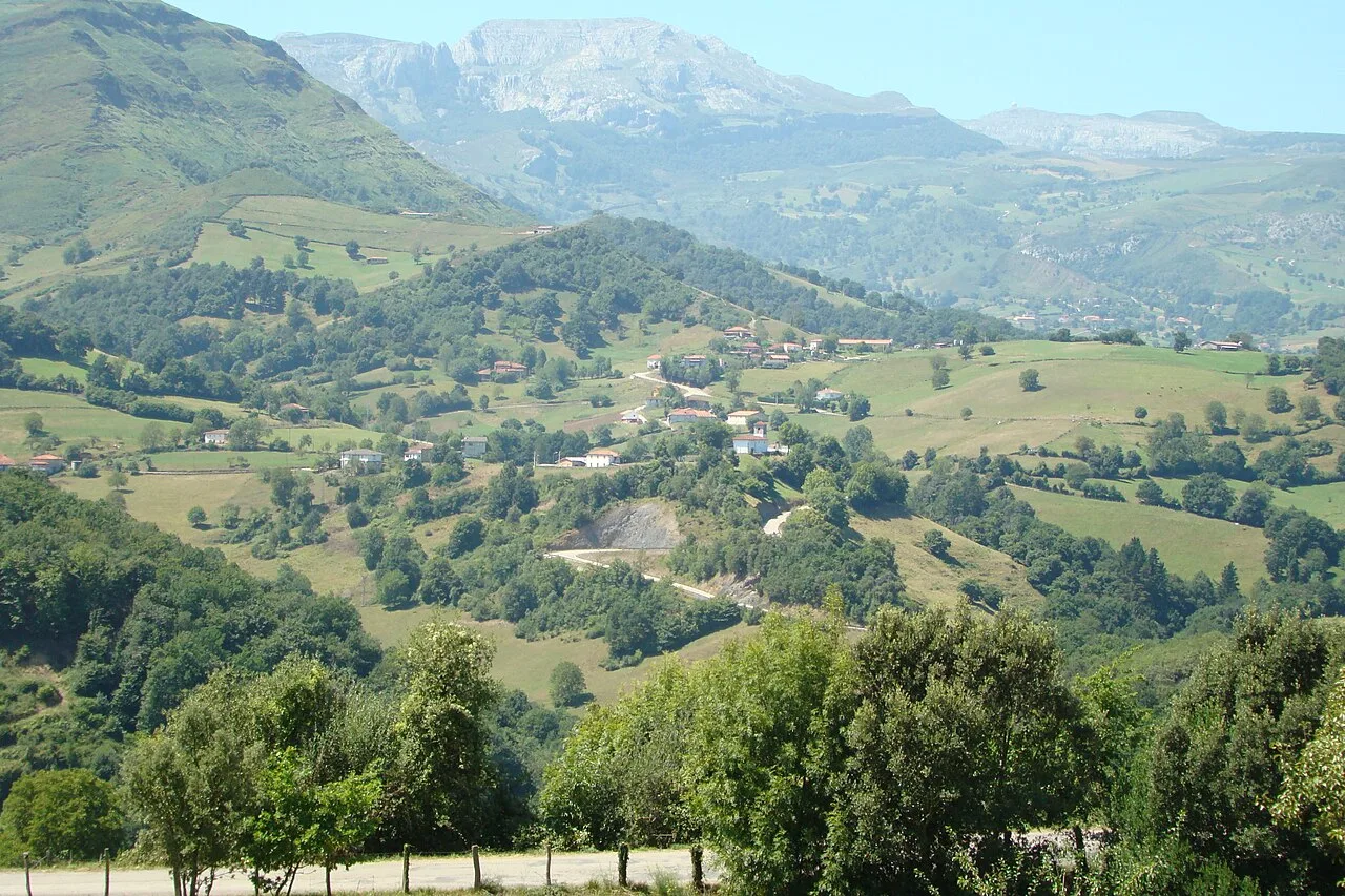 Landschaft des Tals mit Häusern, Bäumen und Bergen in Kantabrien