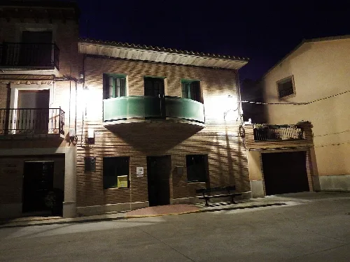 Gebäude mit einem gebogenen Balkon in Barbuñales, Huesca, nachts.