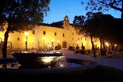 Historisches Gebäude mit Brunnen auf dem Platz, nachts beleuchtet in Torrijos.