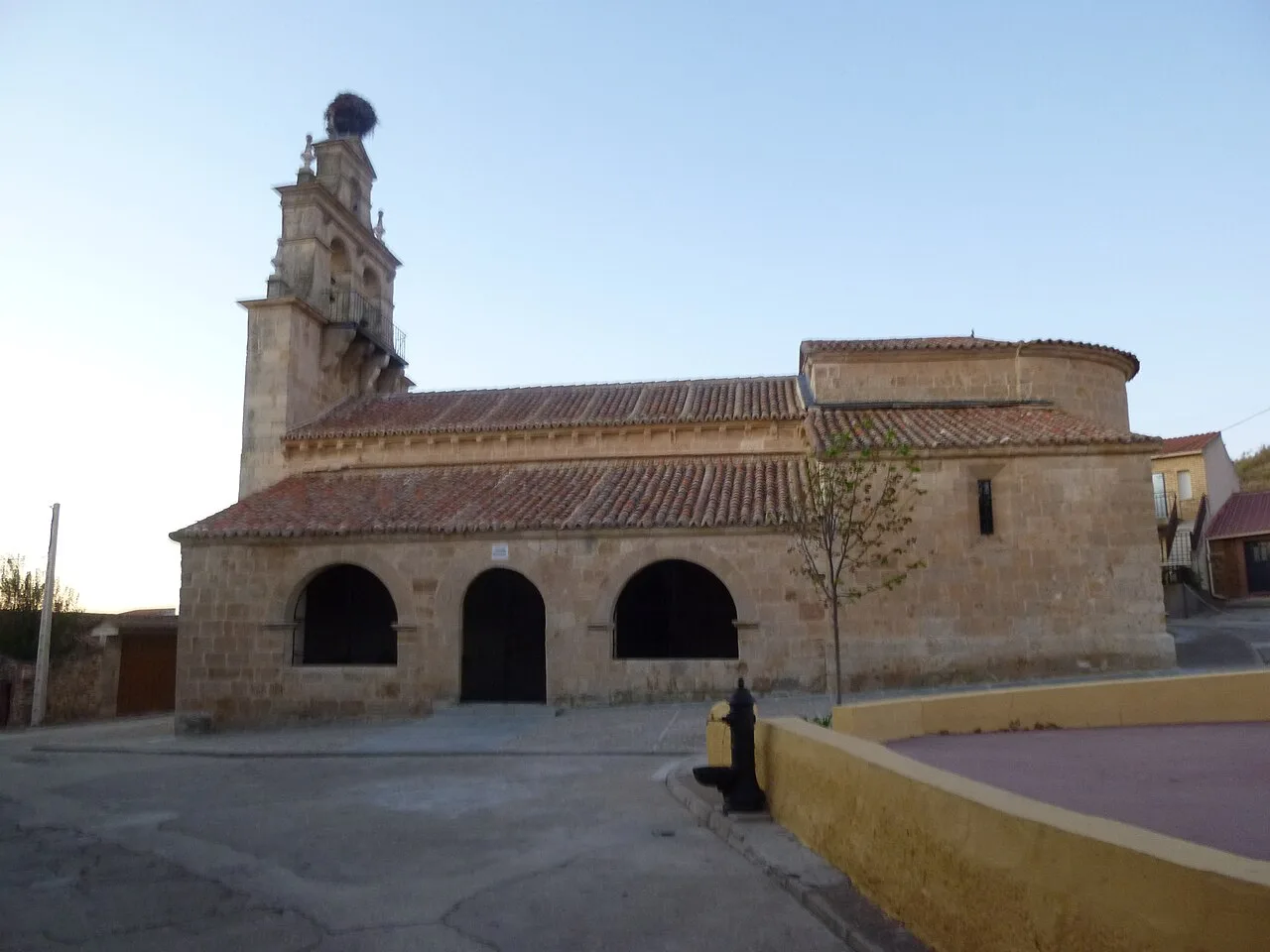 Steinige Kirche mit Turm und Ziegeldach in Almenara de Tormes.