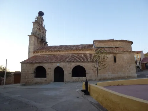 Stone church with tower and tiled roof in Almenara de Tormes.