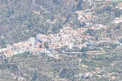 Vista aérea de un pueblo en las montañas con muchas casas blancas.