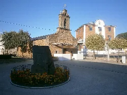 San Roque Chapel and town hall with trees and monument in the foreground.