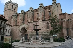 Gothic church façade with fountain in front.