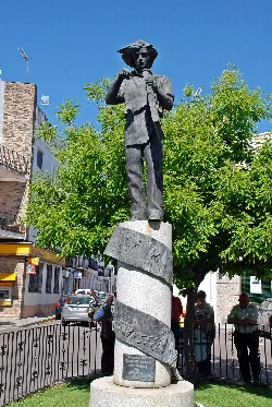 Statue of a boy with a hat and book in a square in San Vicente de Alcántara.