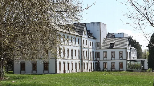 Weißes Spa-Gebäude mit grünen Gärten.