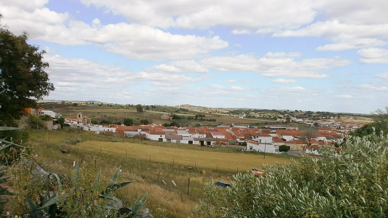 Paisaje rural con casas y campos en La Roca de la Sierra.
