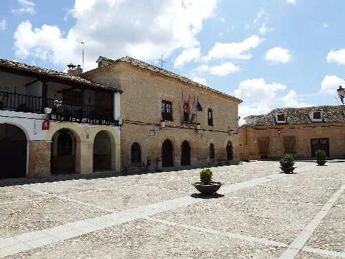 Platz mit Steingebäuden und wolkigem Himmel in Villamayor de Santiago.