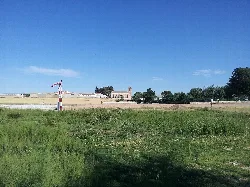 Landscape with Roman bridge, church, and green field in Villarta de San Juan