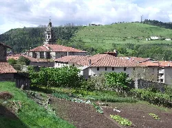 Blick auf alte Gebäude und grüne Hügel in Bergara.