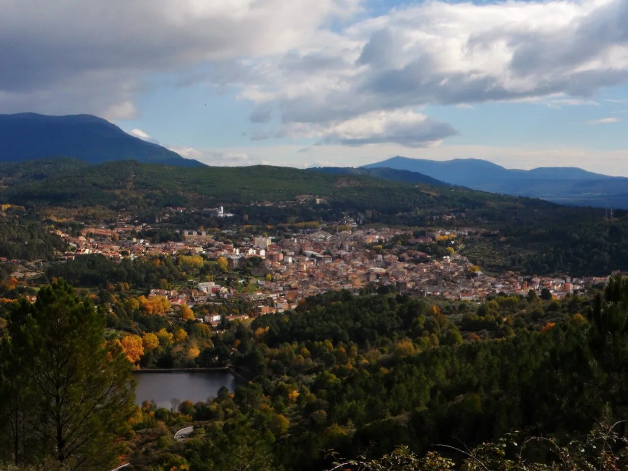 Landscape with town, mountains, and trees.