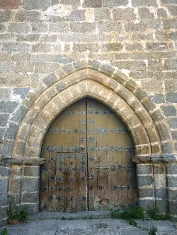 Puerta de madera con herrajes metálicos en la iglesia de El Barco de Ávila.