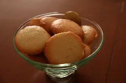 Cookies in a glass bowl on a wooden table.