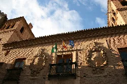 Facade of the Palace of Villalegre with flags and coats of arms in Guadix.