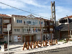 Plaza del Concello en Antas de Ulla con cartel grande y campanario.