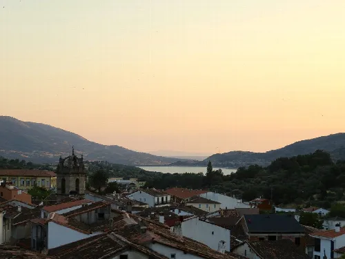 Panoramablick auf Baños de Montemayor mit Bergen und Fluss bei Sonnenuntergang.
