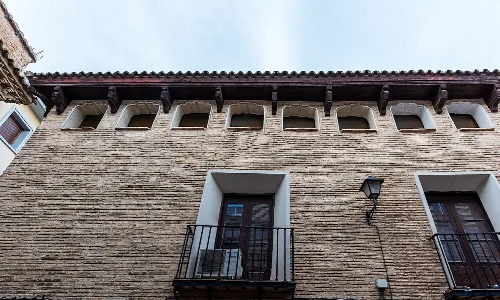 Fassade eines Gebäudes mit Fenstern und Balkon in Alagón, Zaragoza.