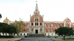 Hospital facade with central tower and trees on the sides.