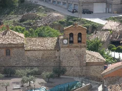 Iglesia de Muro de Aguas con torre y reloj, vista desde lejos.
