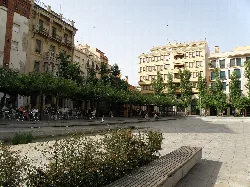 Square with benches, trees, and buildings in Valls, Tarragona.