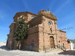 Iglesia de S. Juan Bautista en Vinaceite, con fachada de ladrillo y escalinata.