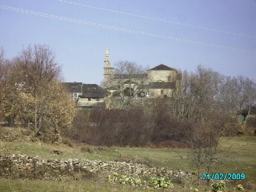 St. Colomba's church in Cobreros with trees and field in the foreground.