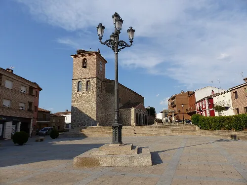 Square with lamp post and stone church in Segurilla.