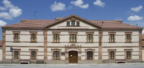 Two-story building with windows and central door, former town hall.