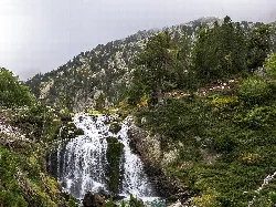 Cascada en un entorno natural con árboles y montañas en Benasque.