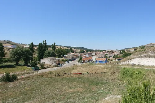 Landscape of Antigüedad with houses, trees, and hills in the background.