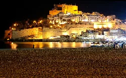 Nachtansicht des historischen Zentrums von Peñíscola mit Burg und beleuchteten Häusern.