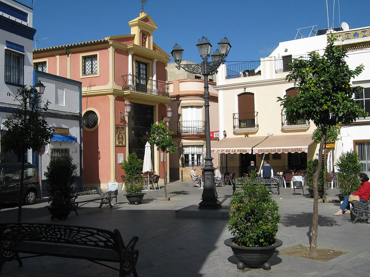 San Francisco Platz mit Bäumen, Bänken und bunten Gebäuden in Isla Cristina.