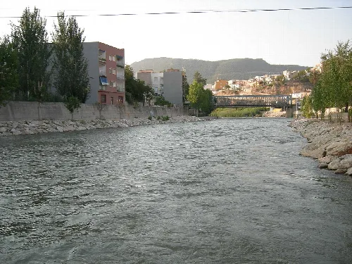 Segura-Fluss in Blanca, Murcia, mit Gebäuden und Bergen im Hintergrund.