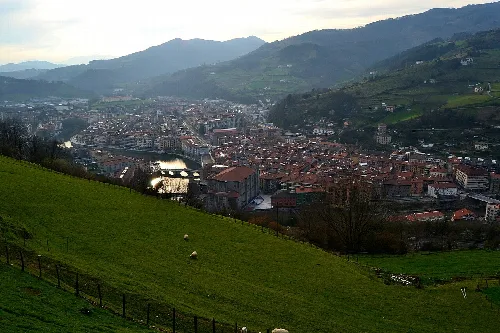 Blick auf Tolosa mit Fluss und Bergen im Hintergrund.