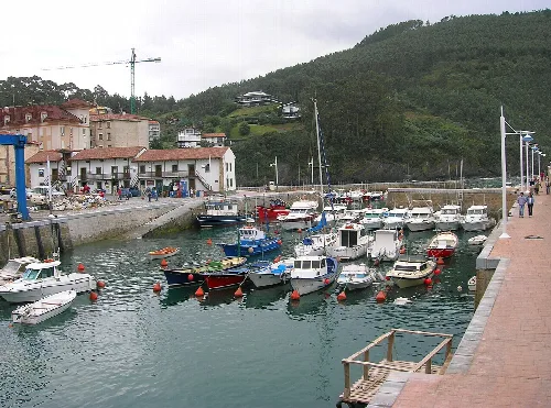 Puerto con barcos amarrados y casas cerca en Lemóniz, Vizcaya.