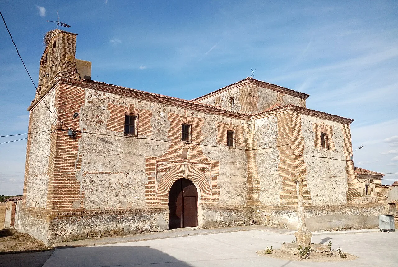 Steinernes Kirchenportal mit Turm auf der linken Seite in San Martín y Mudrián.