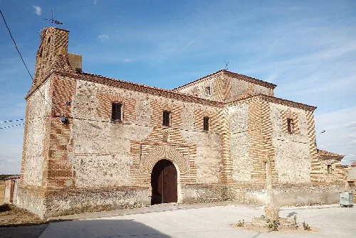 Stone church facade with tower on the left in San Martín y Mudrián.