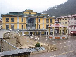 Rathaus in Sotrondio mit Platz und Brunnen im Vordergrund.