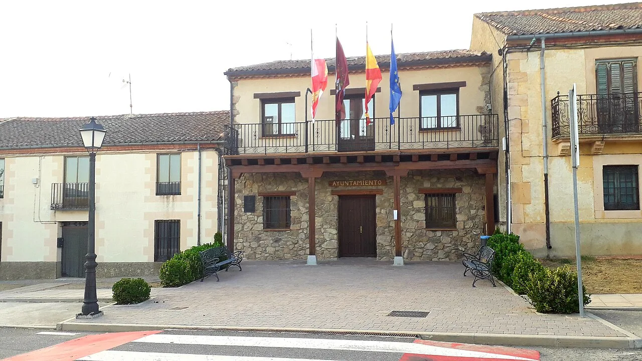 Town hall building with flags and stone entrance in Santo Domingo de Pirón.