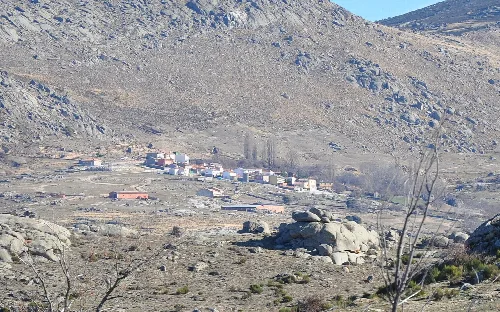 Berglandschaft mit einem kleinen Dorf im Tal.