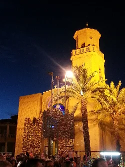 Torre de la iglesia y palmeras en Pilar de la Horadada de noche.