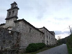 Edificio antiguo de piedra con campanario en Alfoz, Lugo.