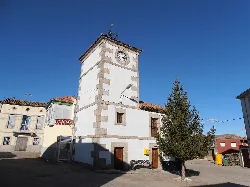 Torre con reloj municipal y árbol en la plaza de Santibáñez de Béjar.
