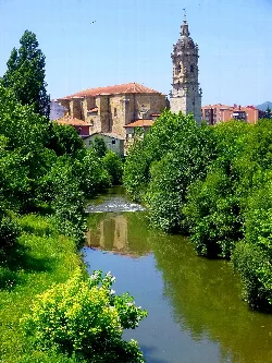 Río Ibaizábal con iglesia y árboles verdes en Amorebieta-Echano.