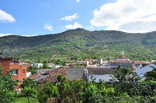 Casar de Palomero mit Häusern und grünen Bergen im Hintergrund