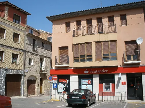Beige building with a balcony and a Santander bank on the ground floor.