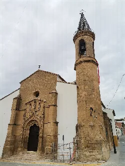 Church with tower and stone and white facade in Lopera.